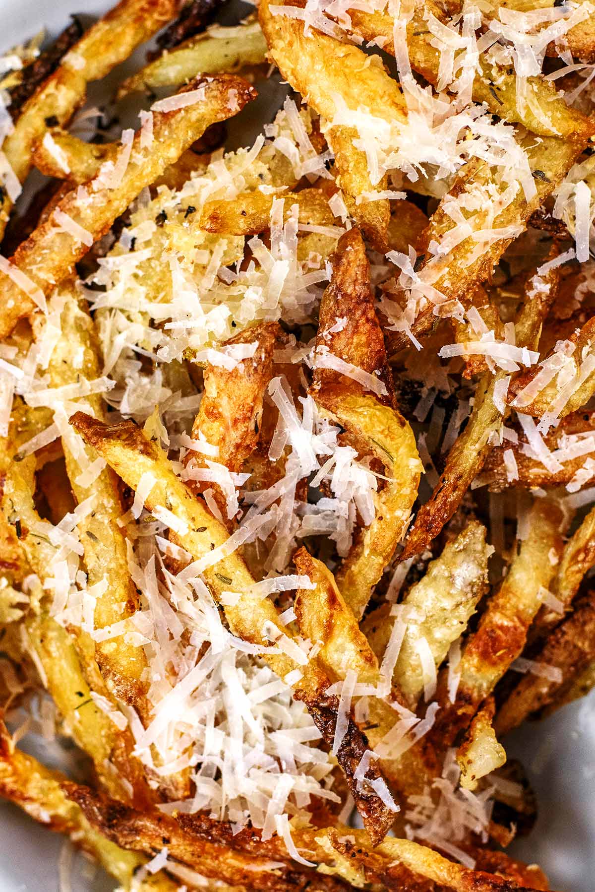 Cooked fries covered in grated Parmesan.