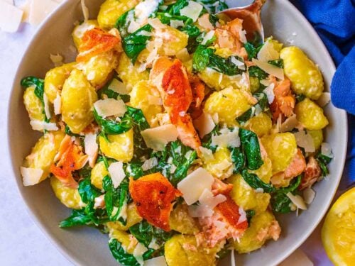 A bowl of 10 minute salmon gnocchi with a spoon.