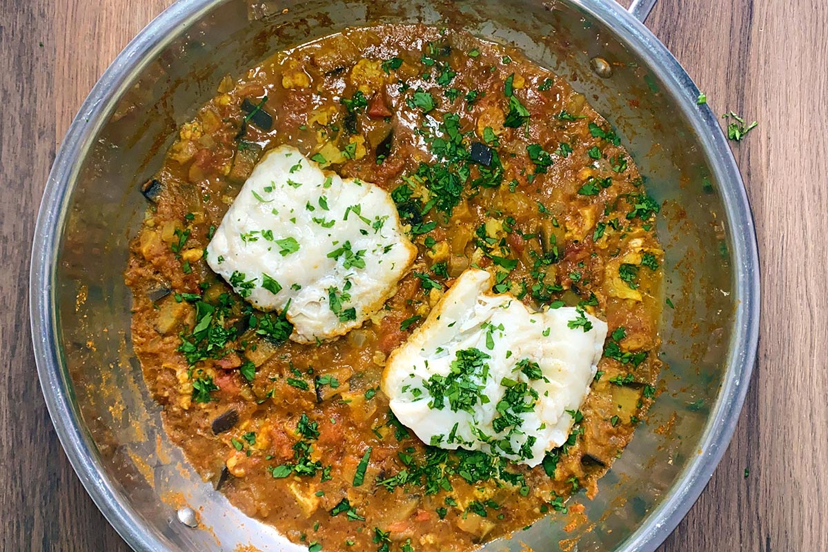 The cooked cod curry with chopped coriander sprinkled over the top of it.