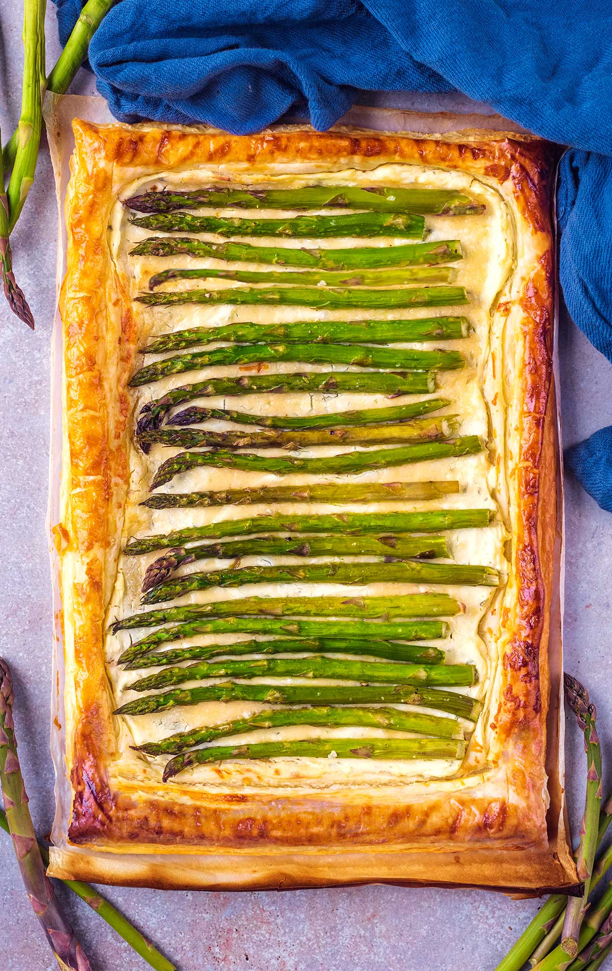 A whole puff pastry tart filled with asparagus spears.