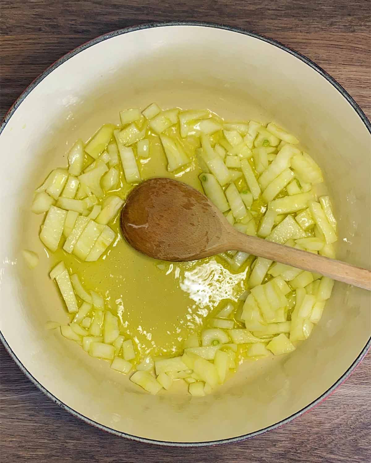 Onions cooking in a large pan.