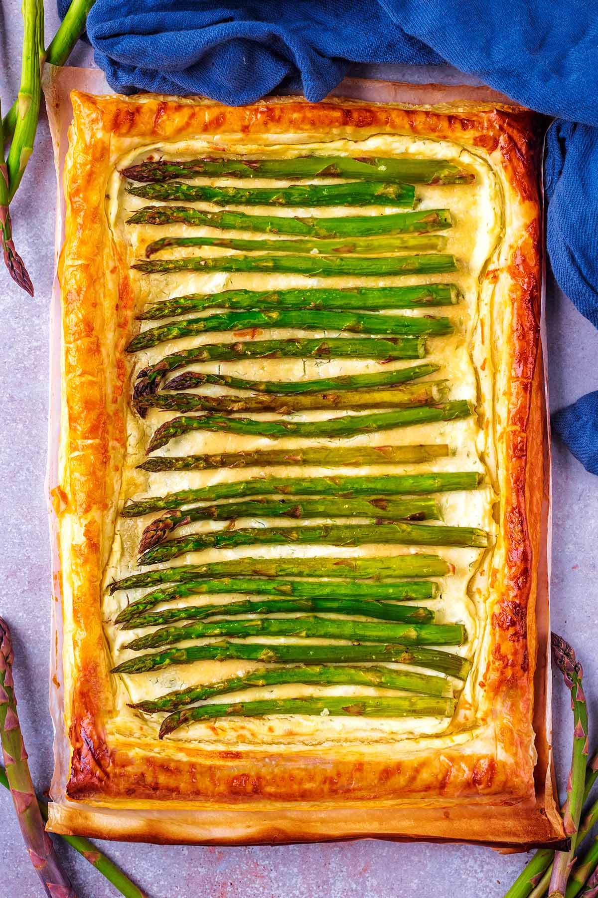 A whole puff pastry tart filled with asparagus spears.