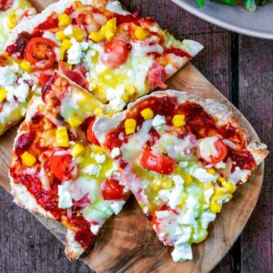 Slices of flatbread pizza on a wooden board.