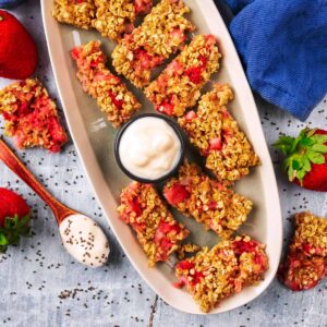 Porridge Fingers on a long serving plate with a small bowl of yogurt.