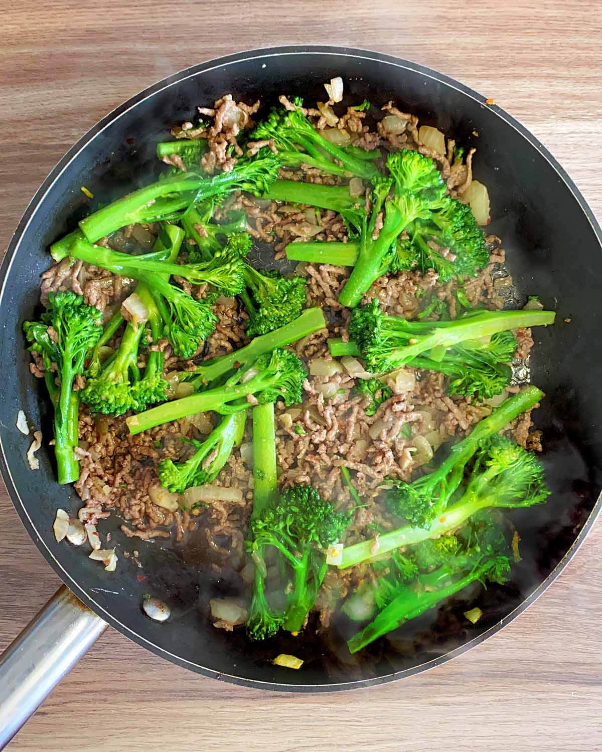 Sauce added and tenderstem broccoli added to the pan.