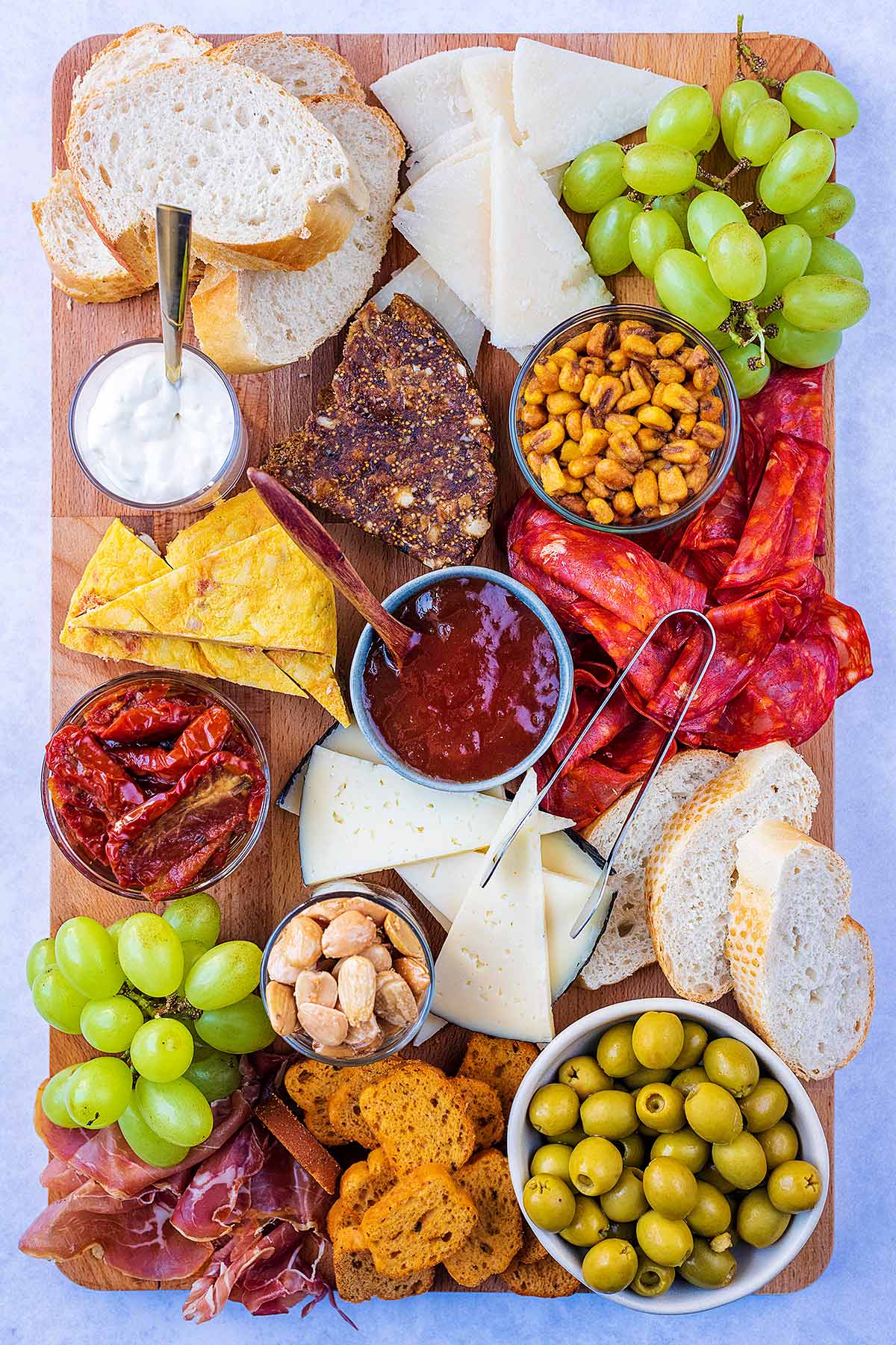 A large rectangular serving board covered in tapas items.