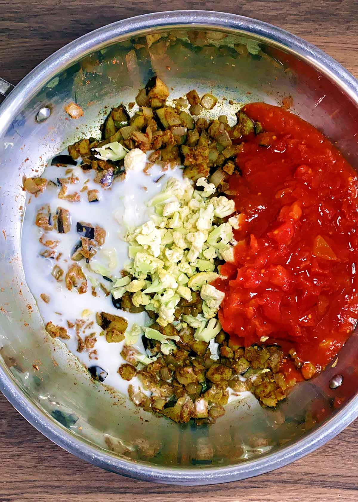 cauliflower, tomatoes and coconut milk added to the pan.