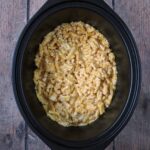 Slow cooker mac and cheese in a black slow cooker bowl.