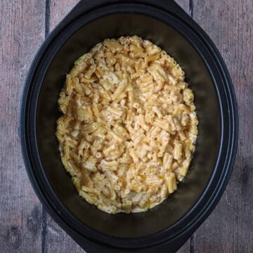 Slow cooker mac and cheese in a black slow cooker bowl.