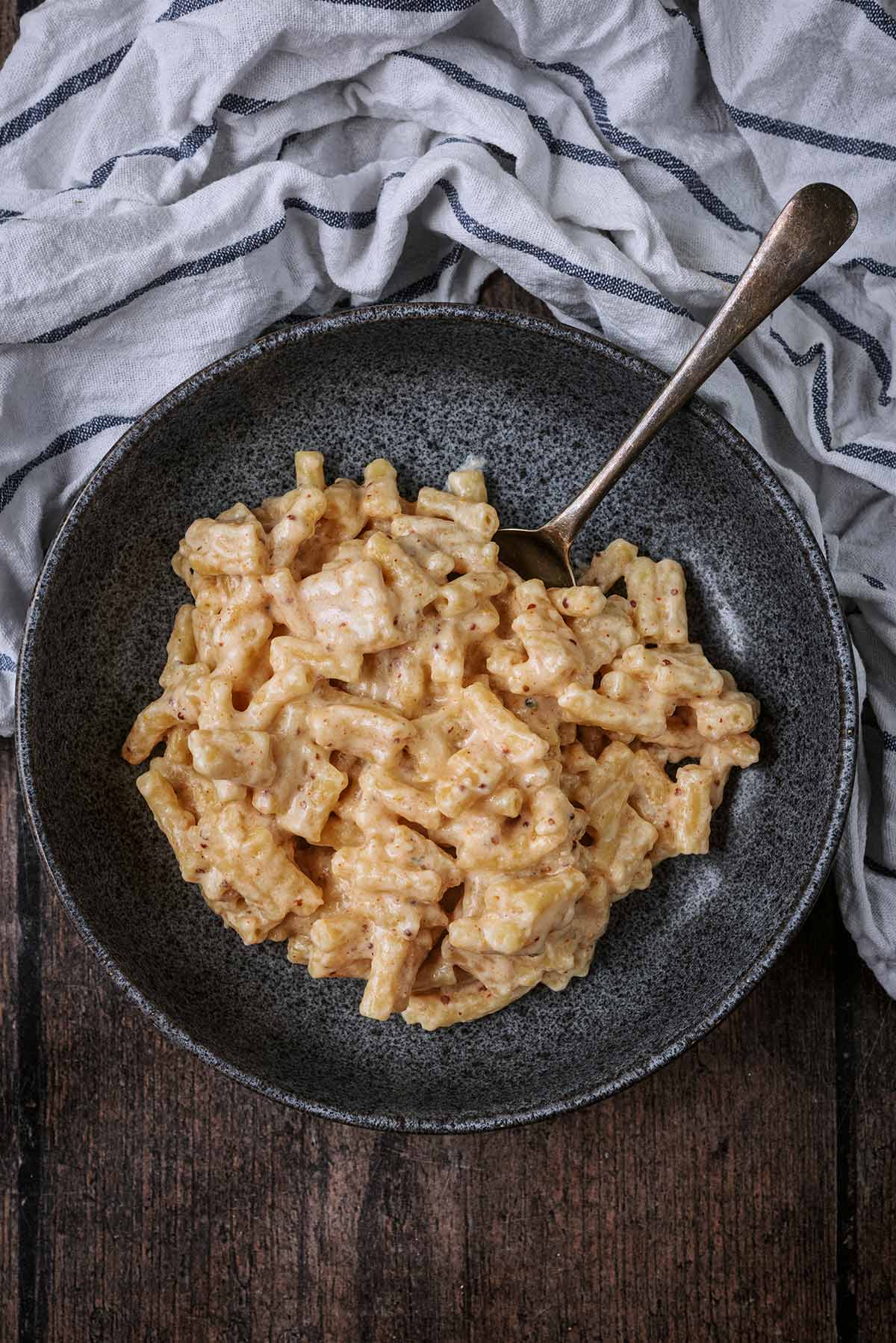 Mac and cheese in a bowl with a spoon.