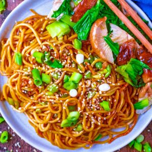 A plate of soy sauce noodles with mushrooms and pak choi.