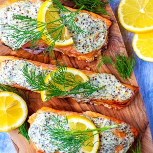 Creamy Dill Salmon topped with lemon slices and sprigs of dill.