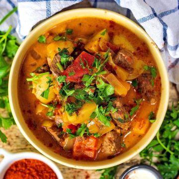 Slow cooker beef goulash topped with coriander leaves.