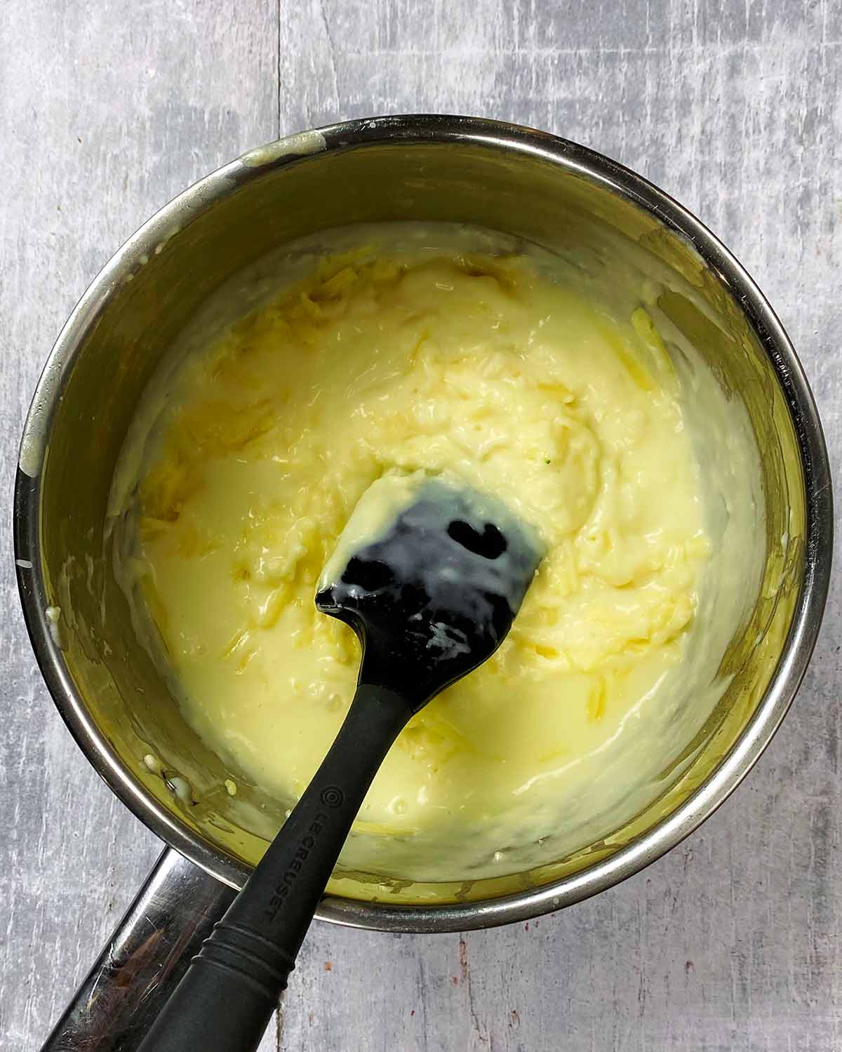 A saucepan containing cheese sauce.