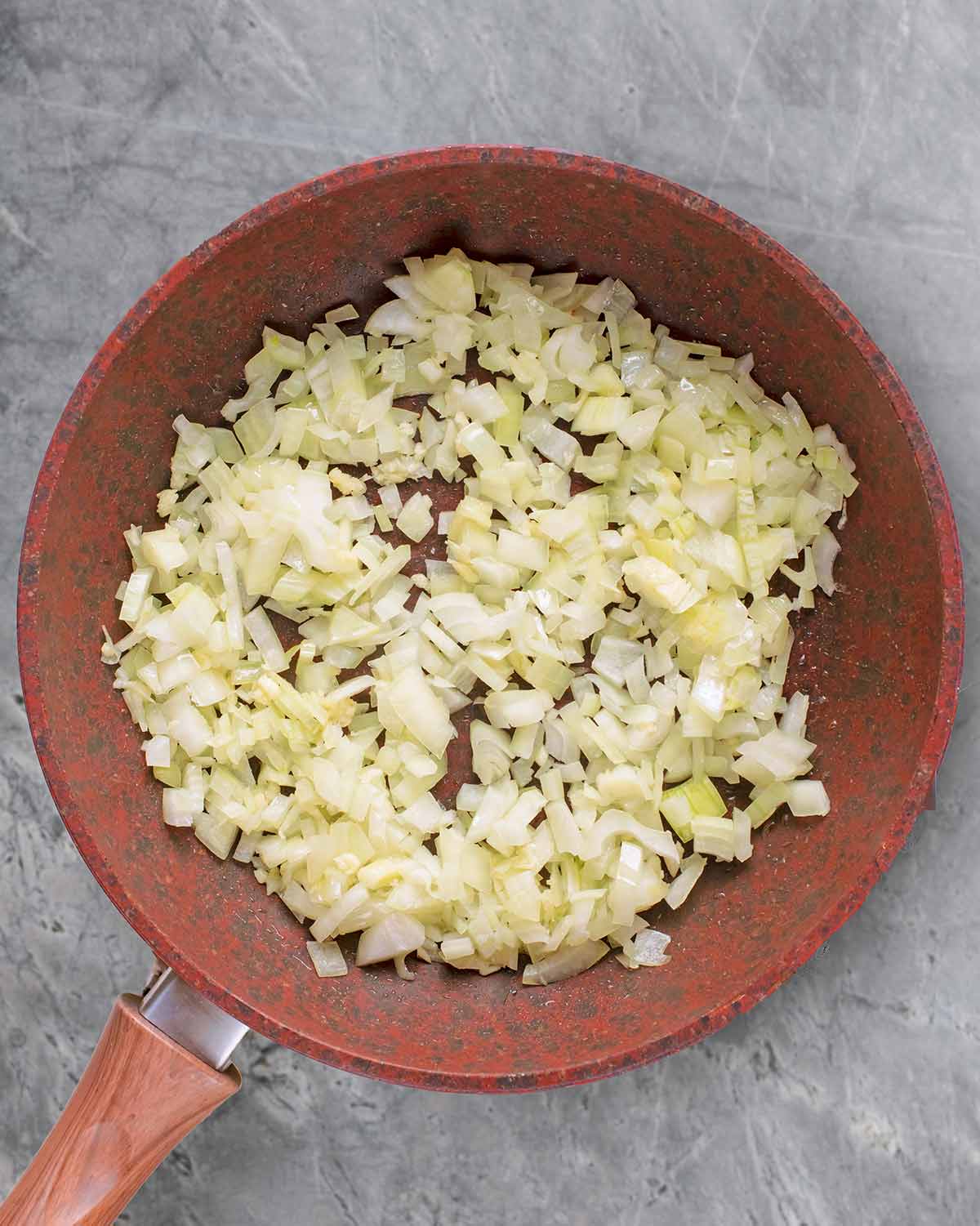 Chopped onions cooking in a frying pan.