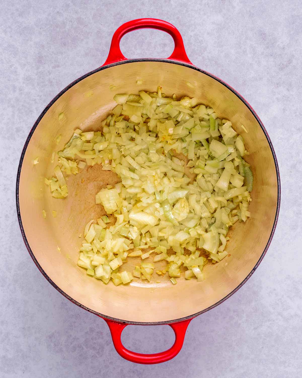 A large pan with chopped onions cooking in it.