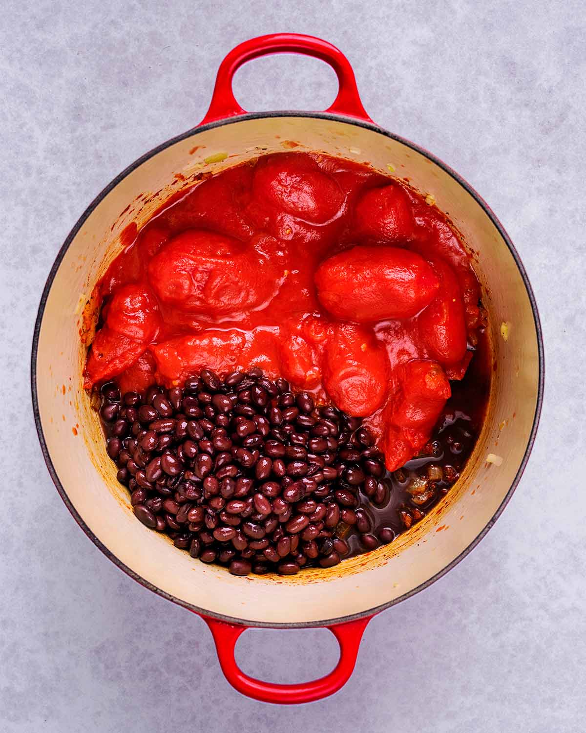 Tomatoes and black beans added to the pan.