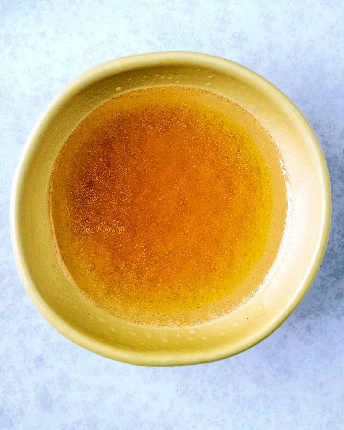 A small bowl of melted coconut oil, honey and vanilla.
