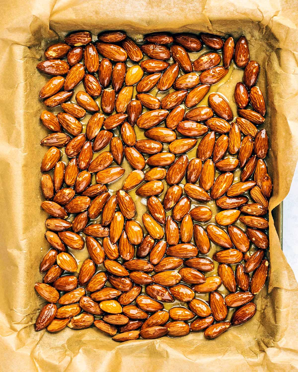 A lined baking tray covered in almonds whole almonds.
