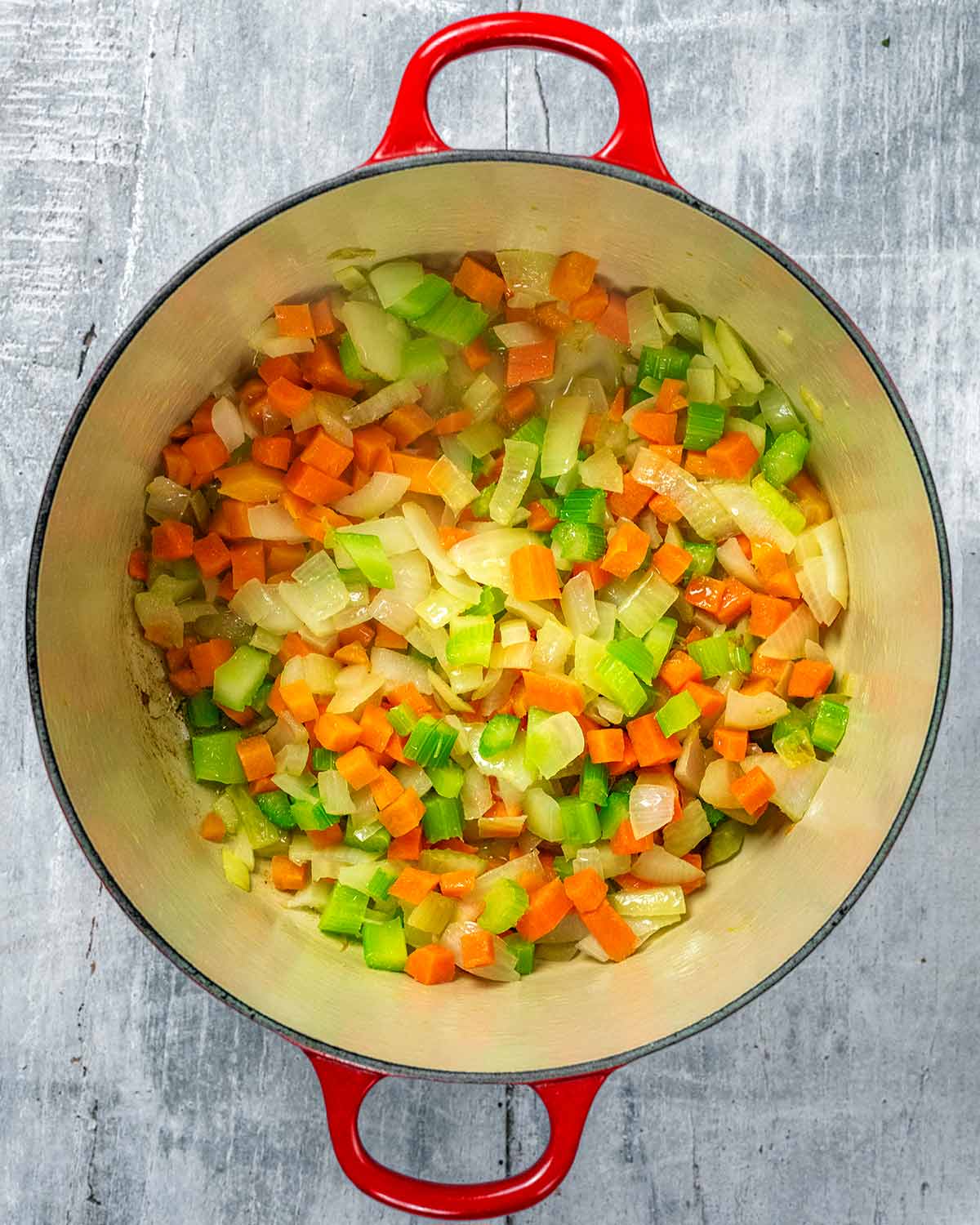 Carrots, celery and onions cooking in a large pan.