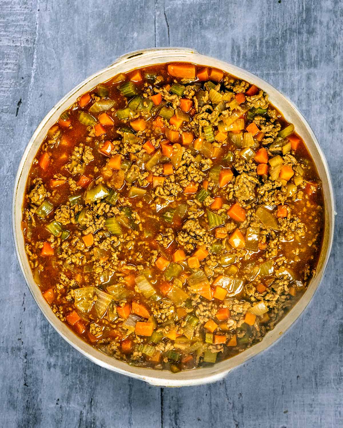 The cooked mince and vegetables in a large round baking dish.