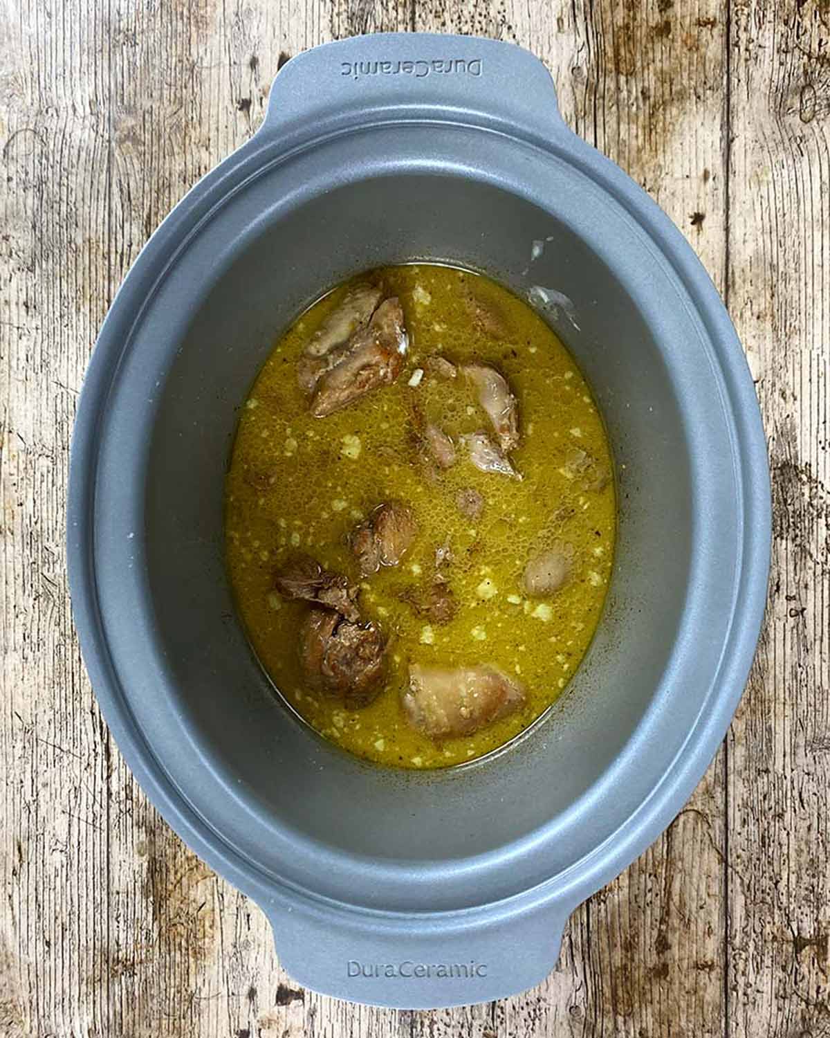 Cooked chicken in sauce in a slow cooker.