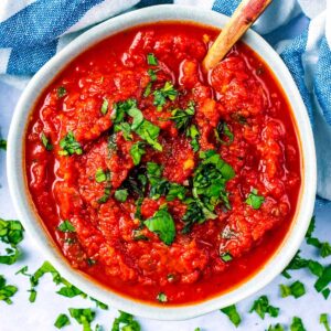 Easy Pizza Sauce in a bowl topped with chopped basil.