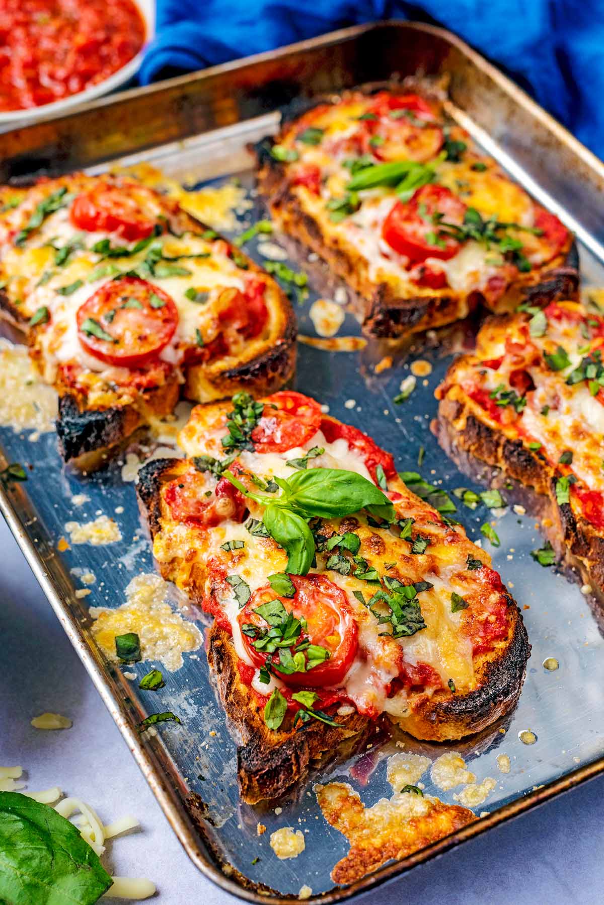 Slices of pizza toast topped with basil leaves.