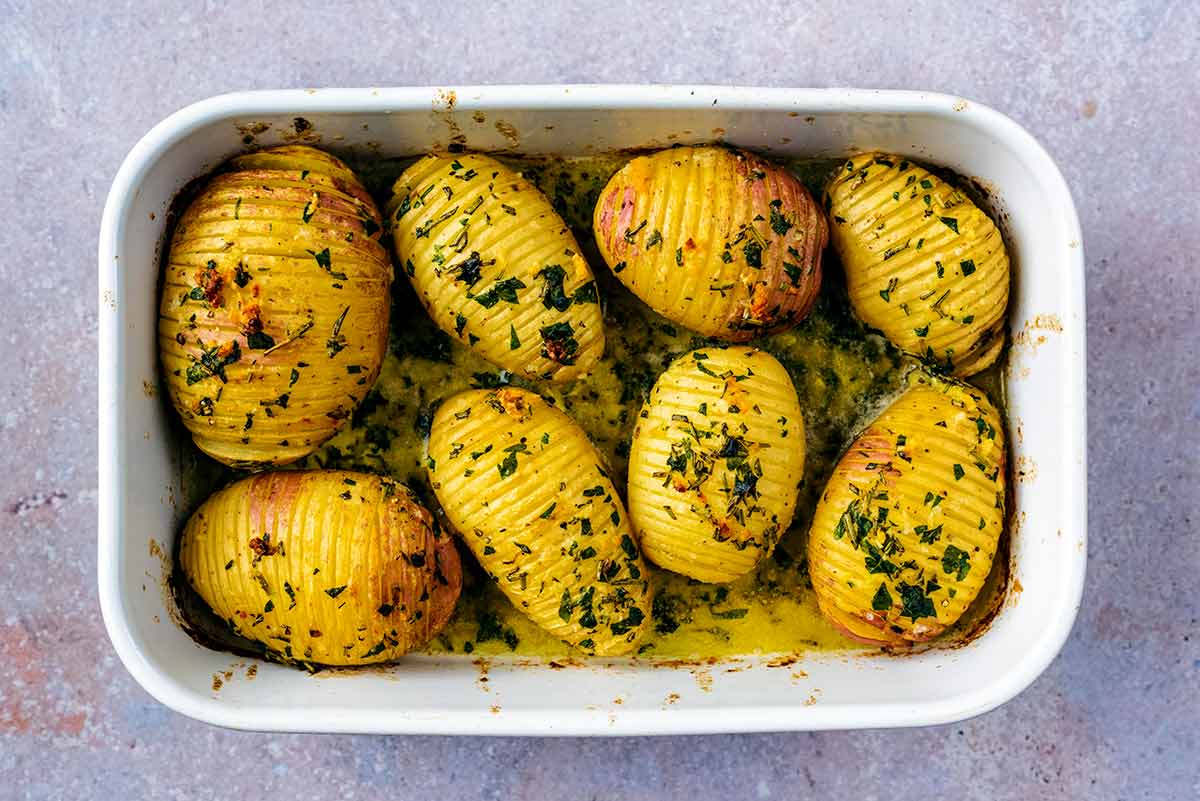 Cooked hasselback potatoes in a baking dish.