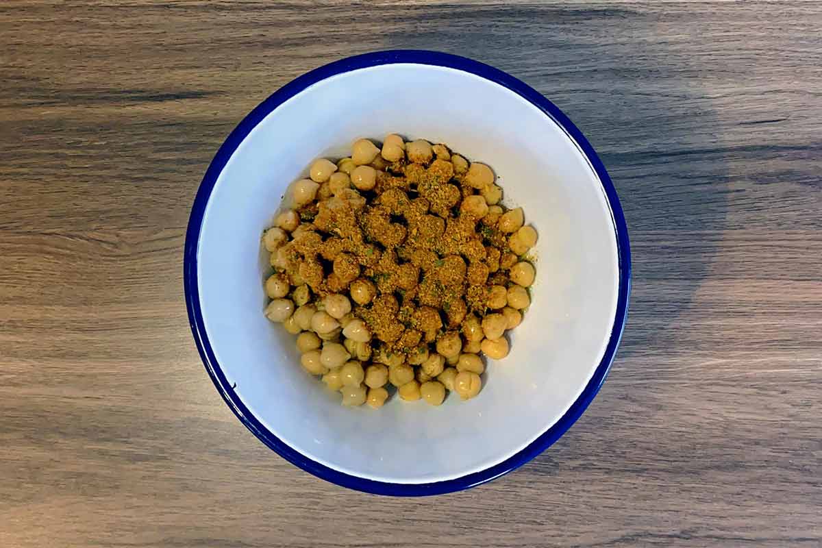 Chickpeas and spice blend in a bowl.