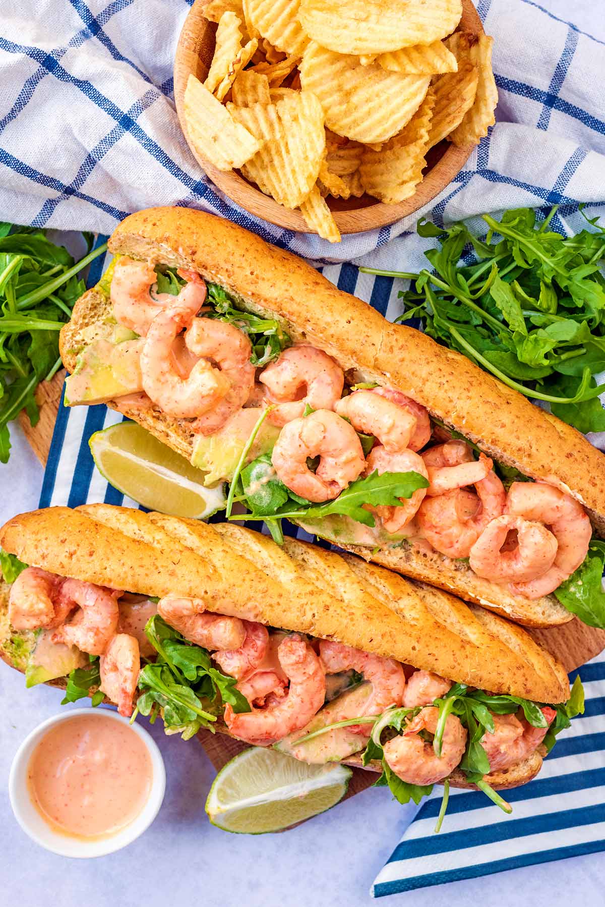 Two baguettes filled with salad and prawns in a creamy sauce.