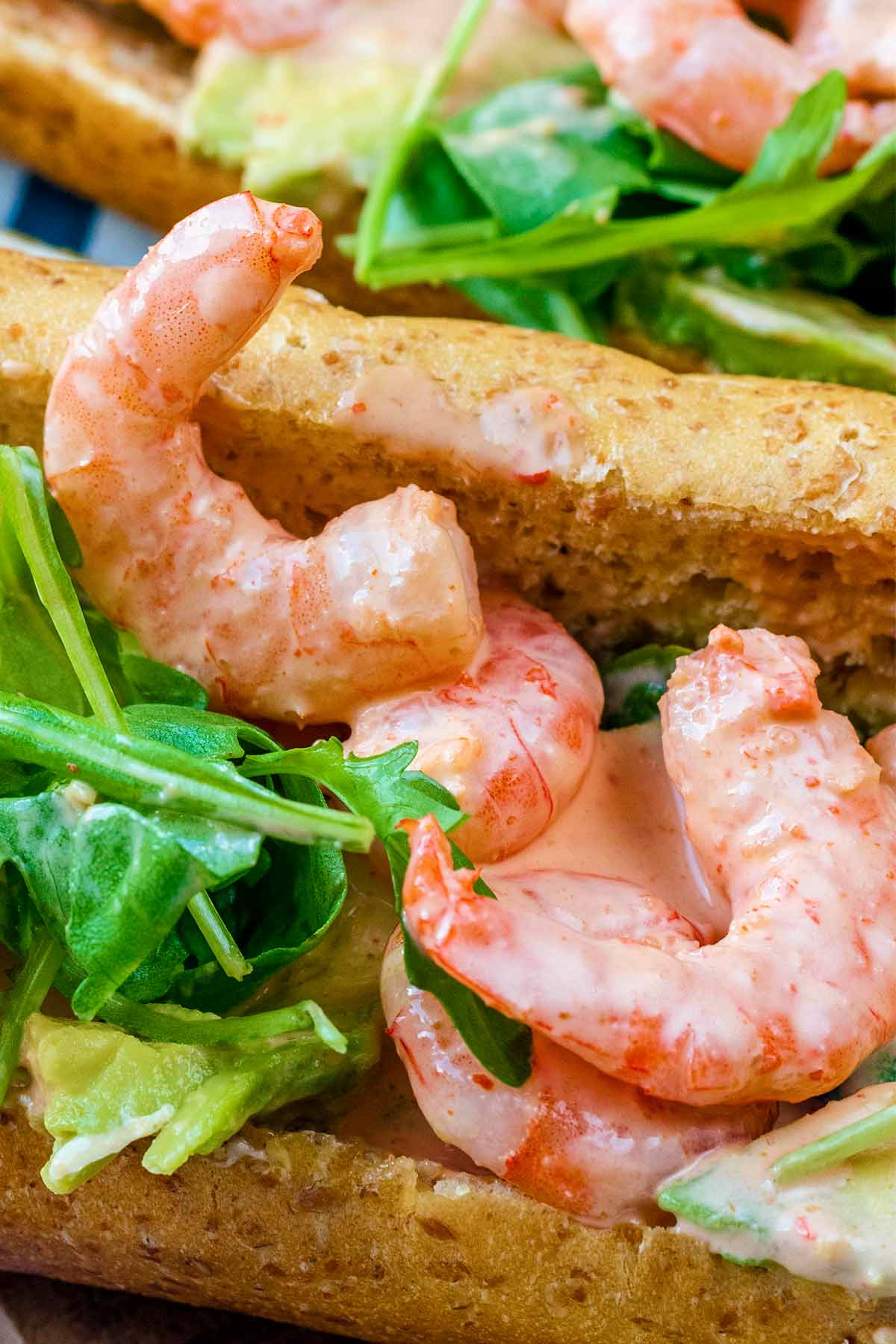 Prawns in a creamy sauce in a sandwich with lettuce.