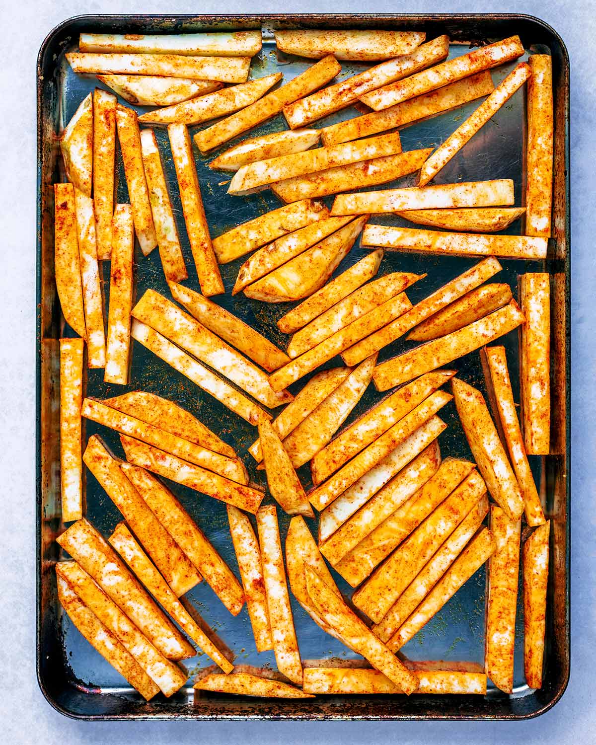 A baking tray covered in the the chips, ready to be cooked.