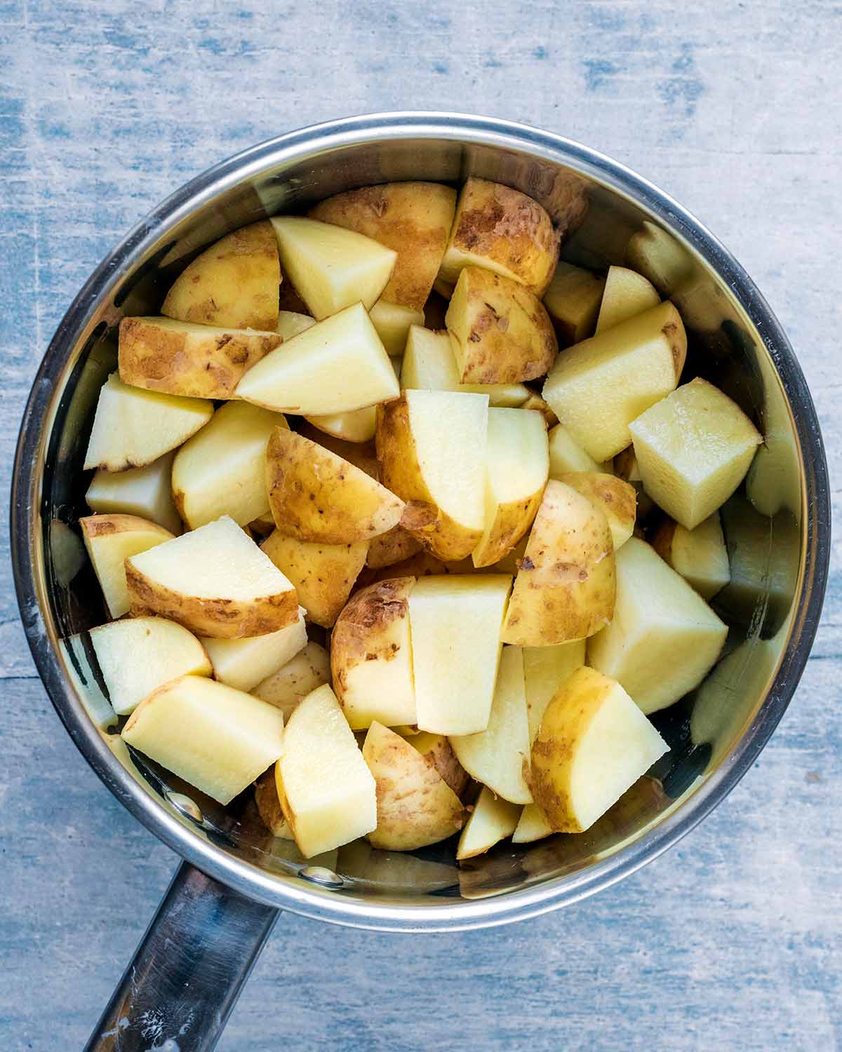 A saucepan full of chopped potatoes.