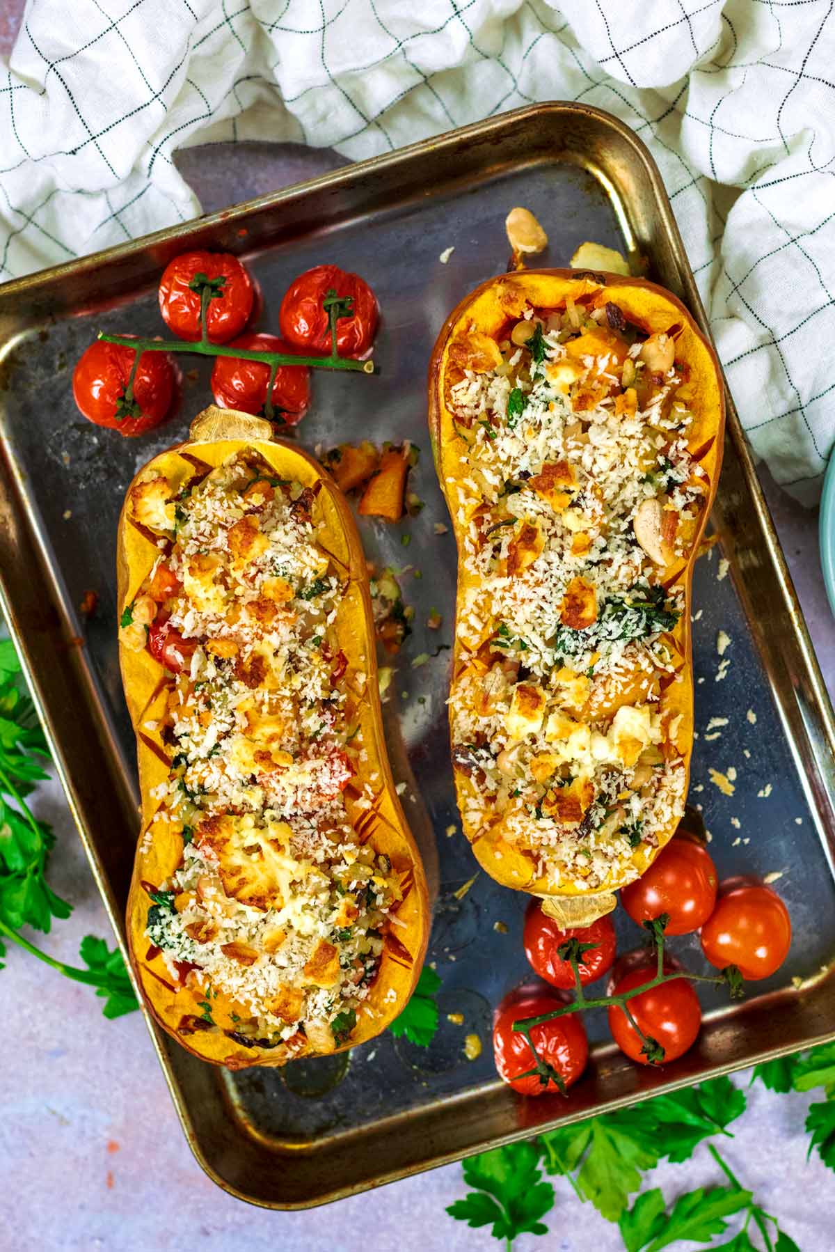 Two butternut squash halves stuffed with rice, vegetables and cheese.