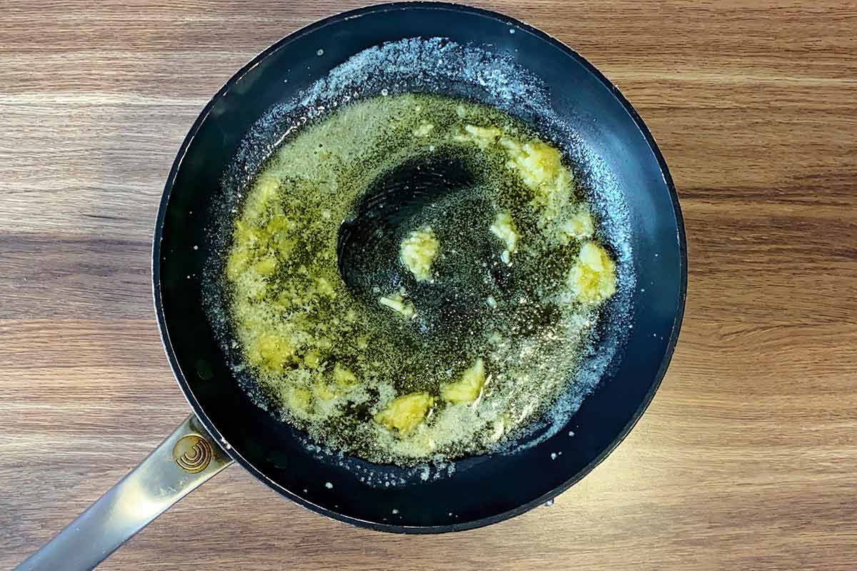 Minced garlic frying in butter in a pan.