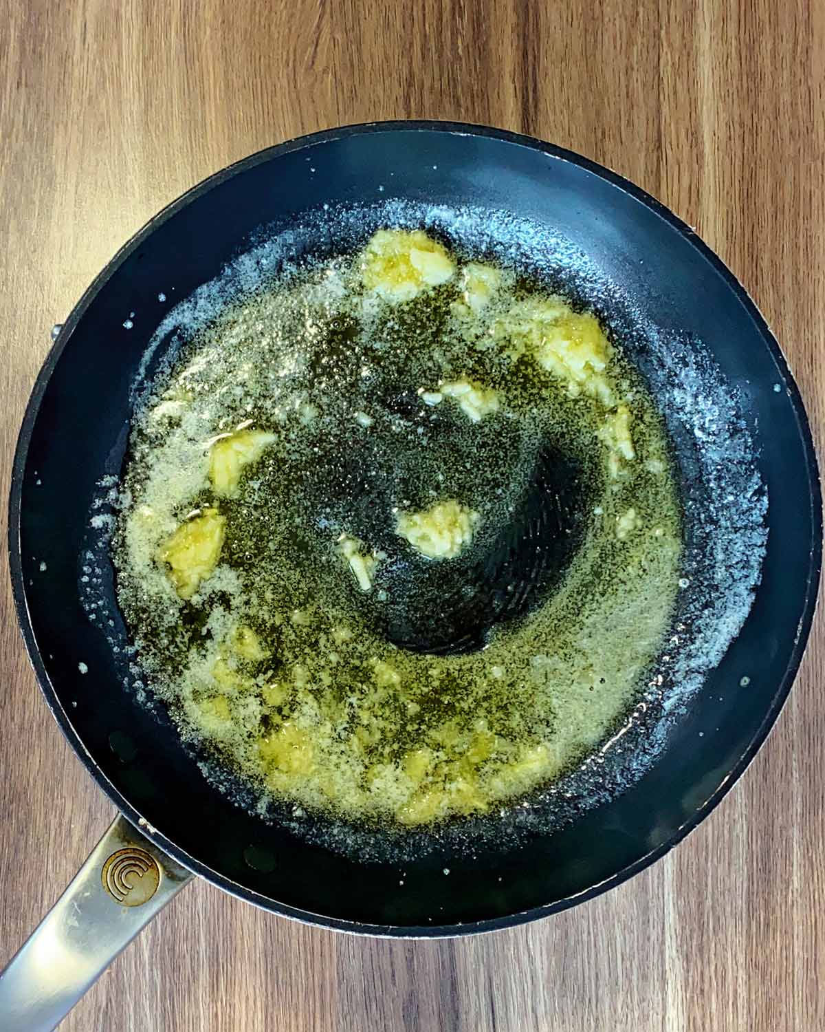 Minced garlic frying in butter in a pan.