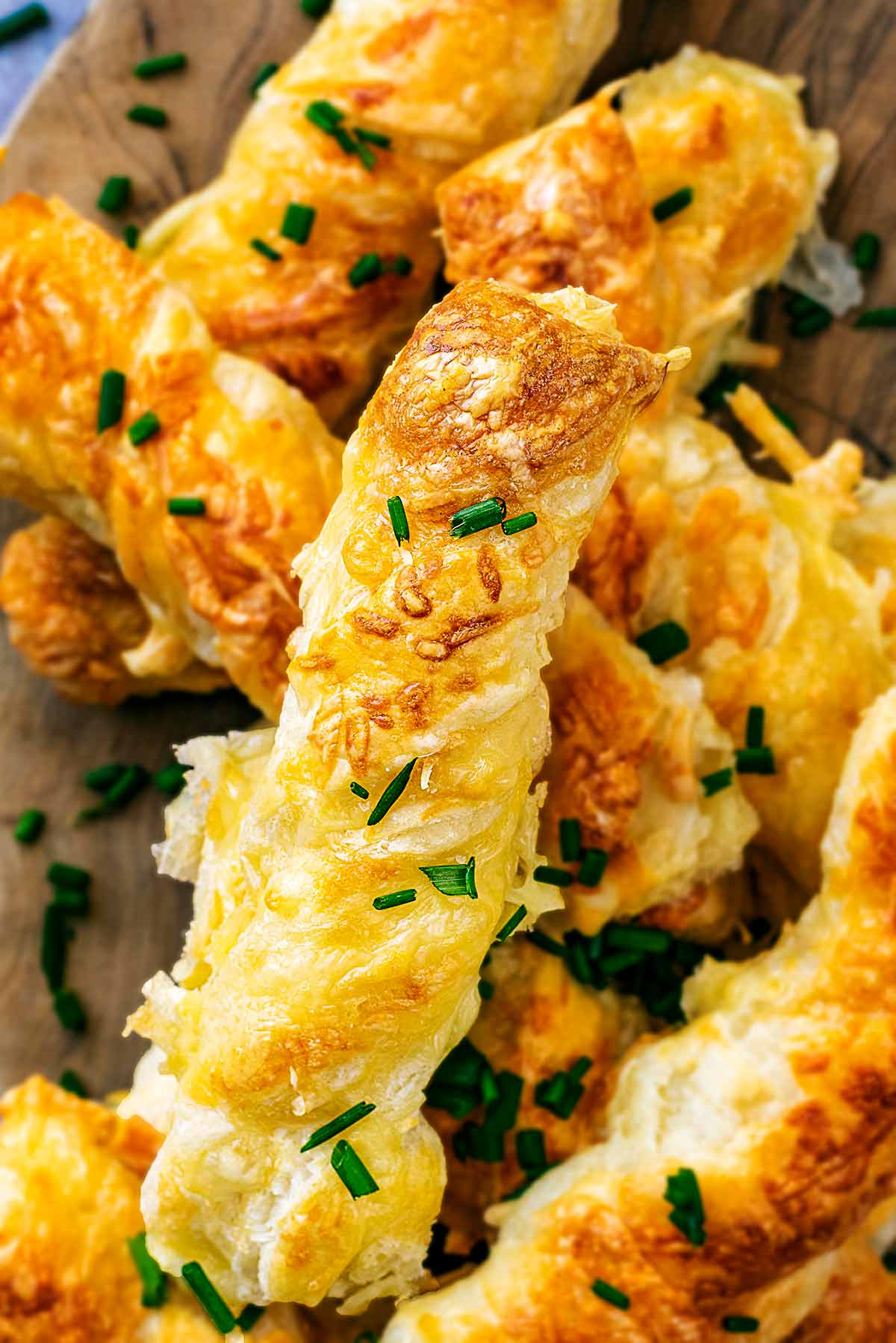 Cheese straws wiht chopped chives sprinkled over them.