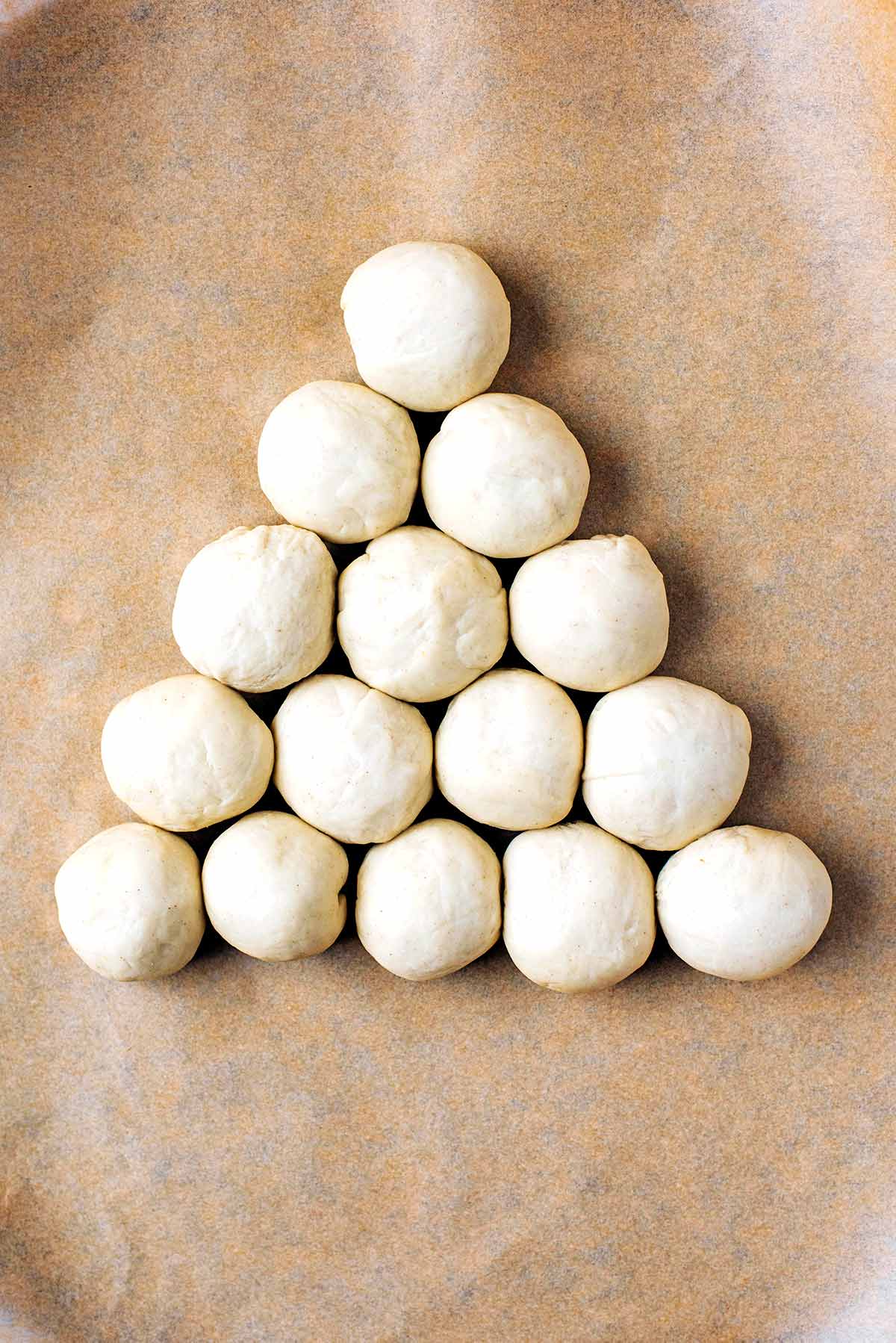 Fifteen dough balls arranged in a triangle.