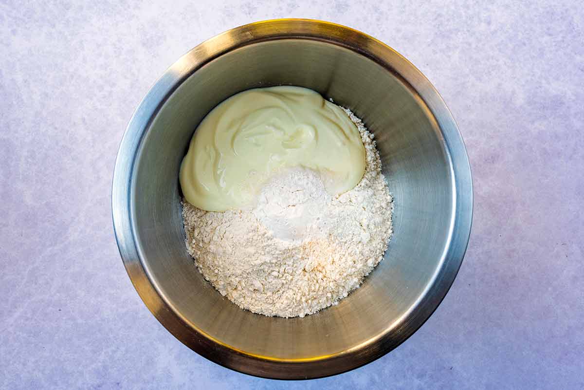 A mixing bowl containing flour and yogurt.