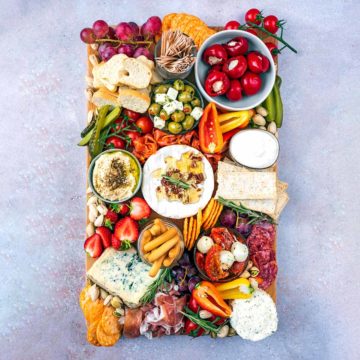 A grazing platter containing various meats, cheeses and vegetables.