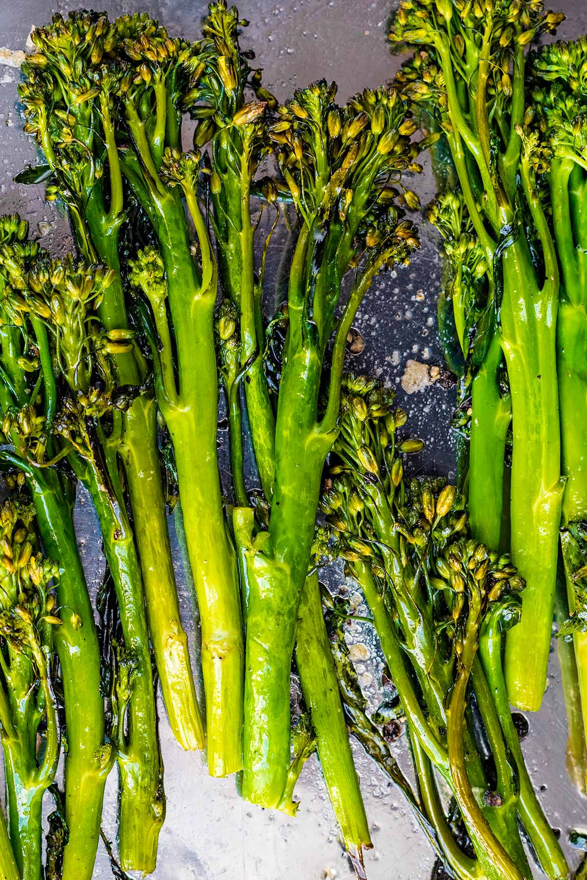 Roasted broccoli and garlic on a baking tray.