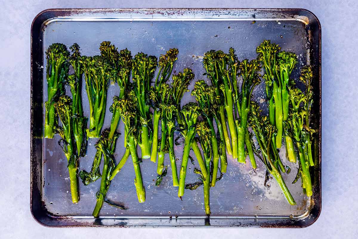 Roasted broccoli on a baking tray.