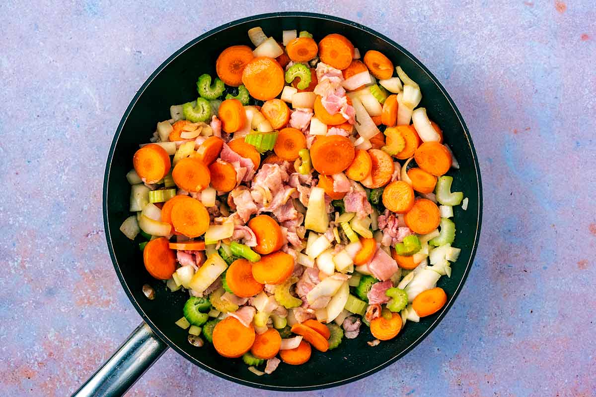 Chopped bacon and vegetables cooking in the pan.