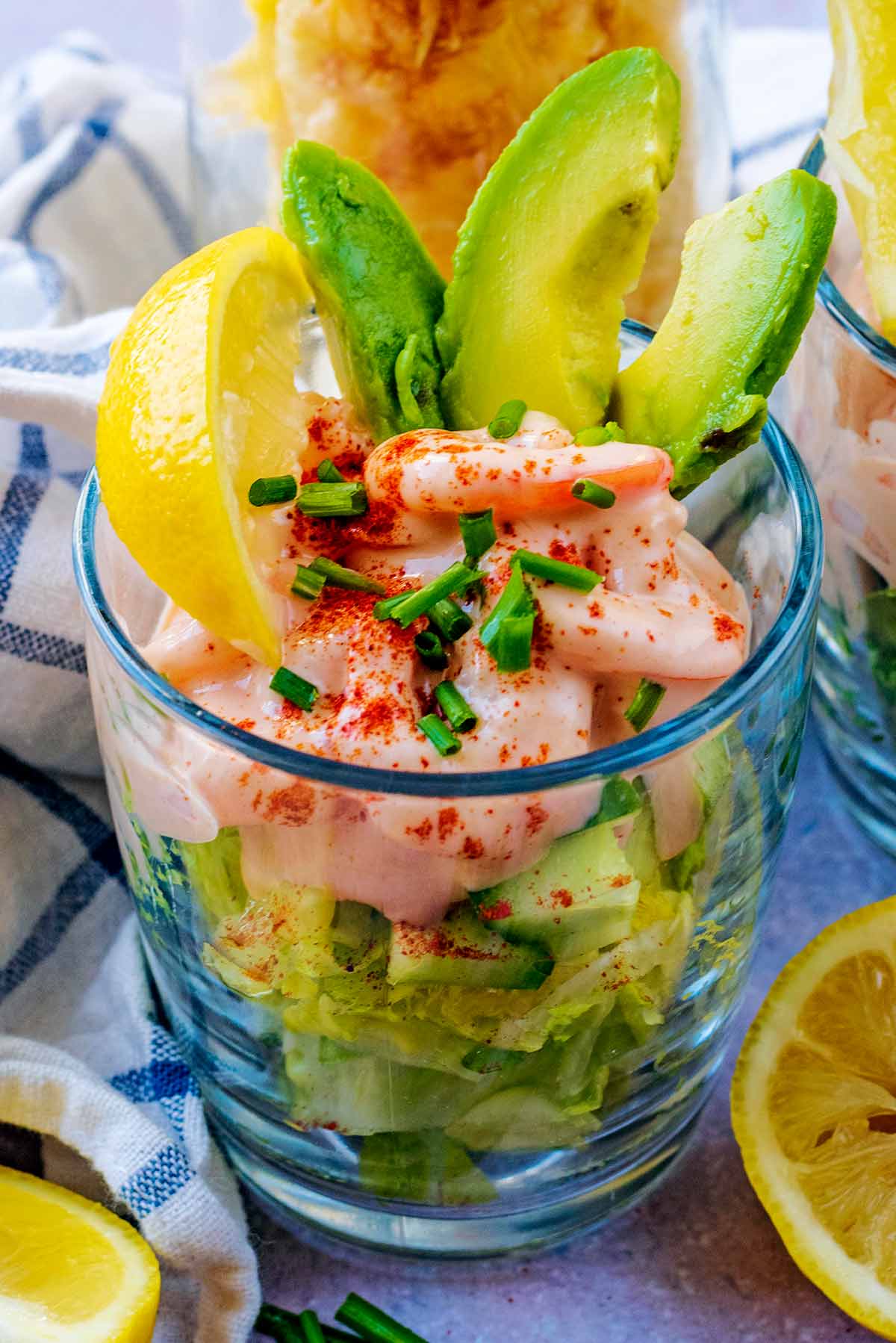 A glass of prawn cocktail topped with chopped chives.