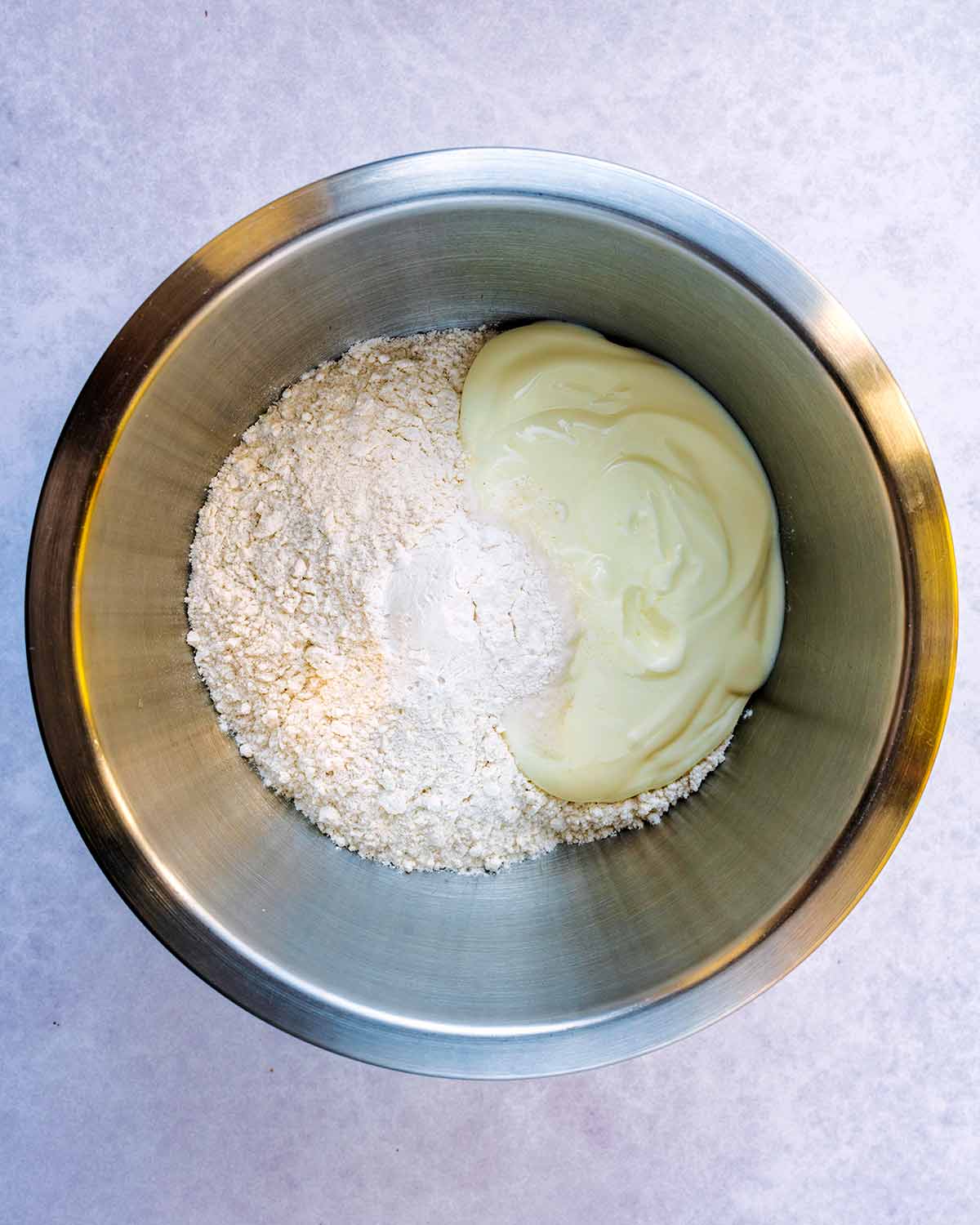 A mixing bowl containing flour and yogurt.