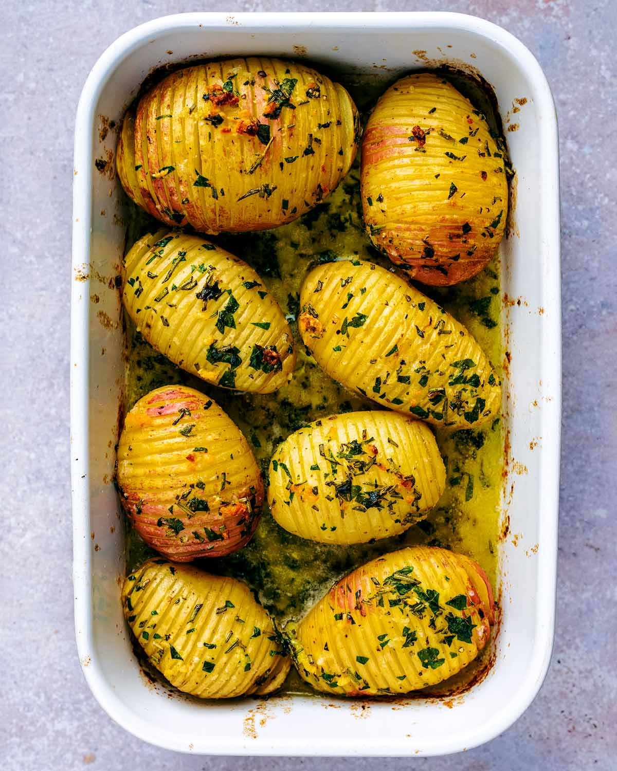 Cooked hasselback potatoes in a baking dish.
