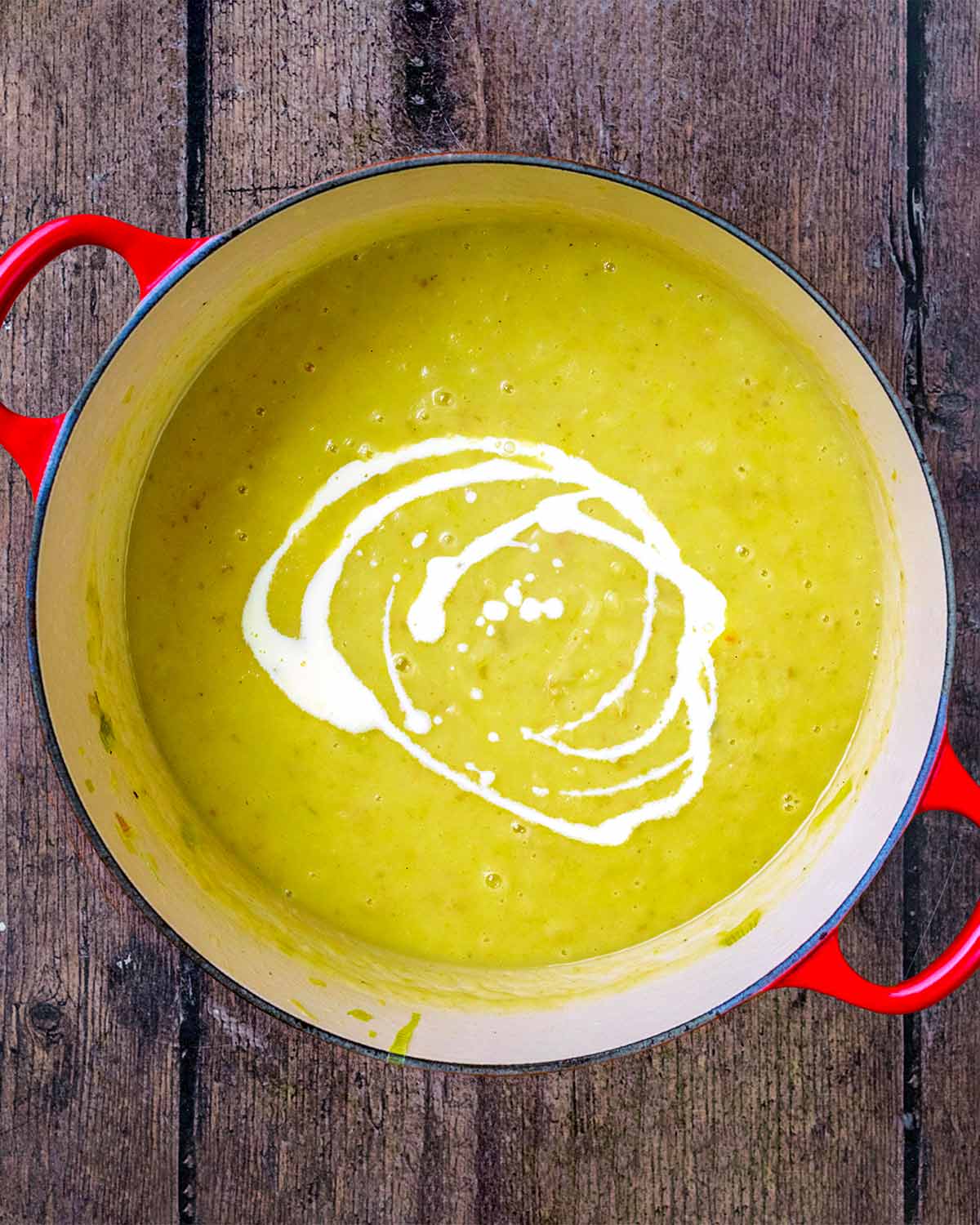 A swirl of cream added to the top of the blended soup.