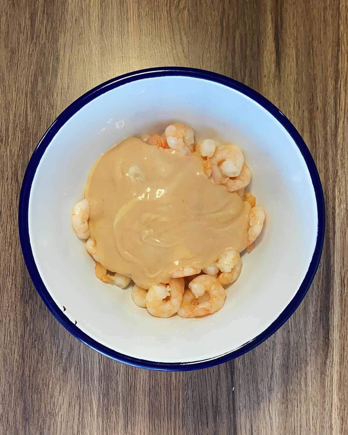 A bowl with prawns and Marie Rose sauce in it.