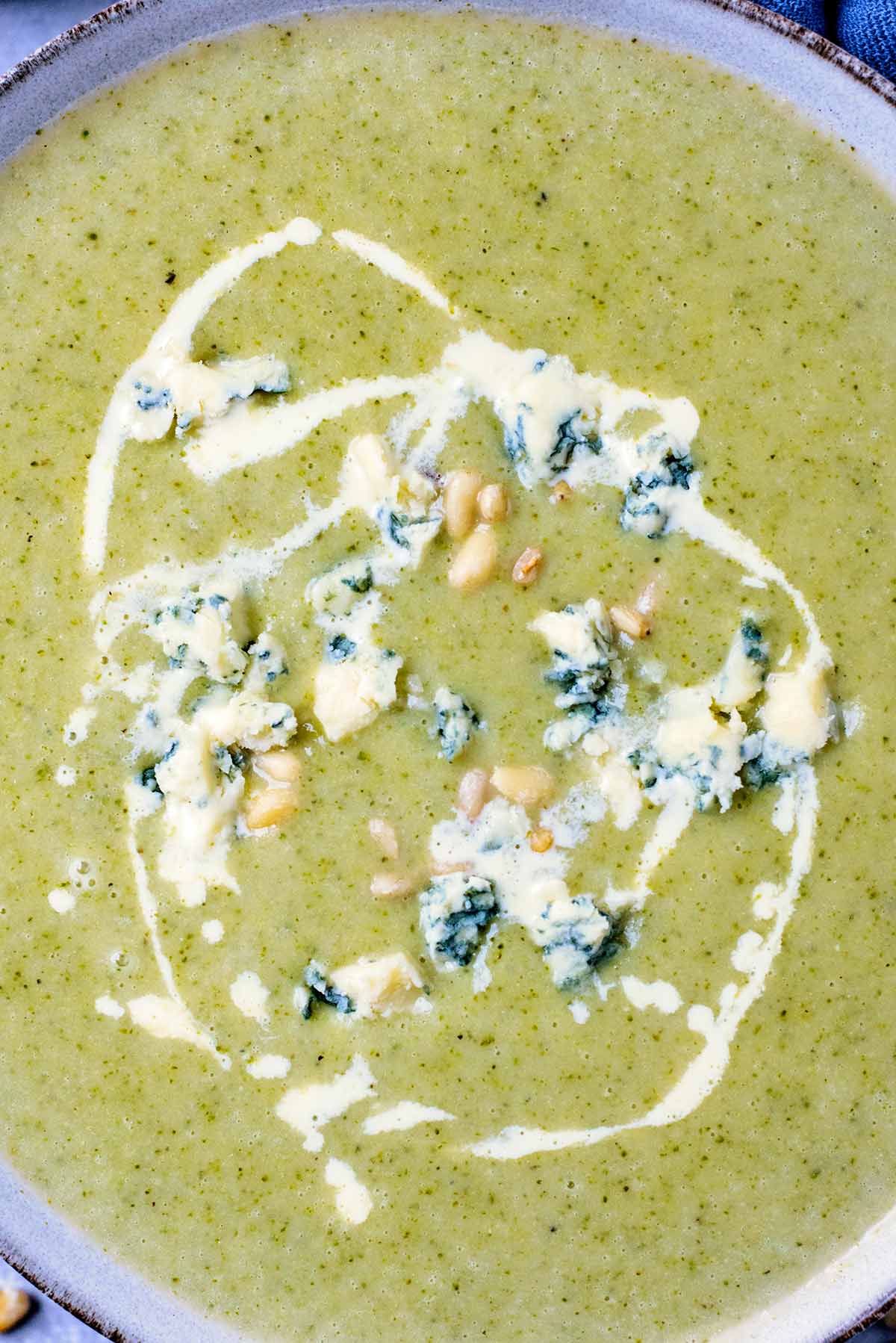 Cream drizzled on top of soup with crumbled stilton added.